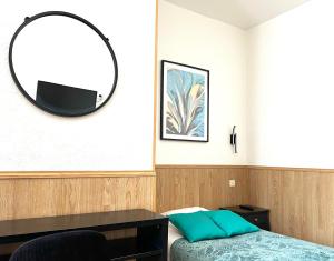 瑟堡德拉卡尔酒店的一间带镜子、一张床和一张书桌的卧室