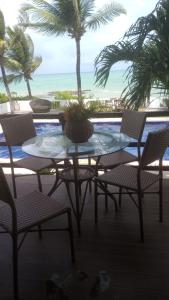 雅克南Sereia do Mar Pousada Carapibus的一张桌子和椅子,享有海滩美景