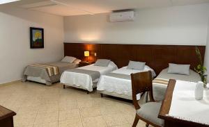 亚松森Terrazas Vista Verde的酒店客房带两张床和一张桌子以及椅子。