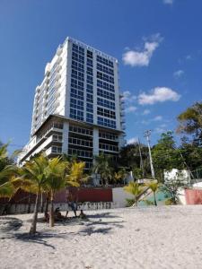 La ChumicosaPh Ibiza Playa Corona的海滩前有棕榈树的高楼