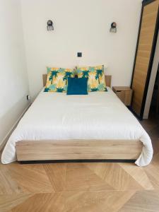 南莱潘Maisonnette indépendante avec jardin privatif vue Sainte Baume的卧室配有带蓝色枕头的大型白色床