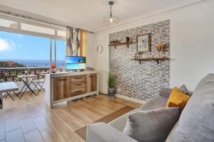 滨海帕尔姆Margherita House Tenerife, Wonderful Ocean View的客厅配有沙发和带电视的桌子