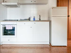 恩纳Al Duomo的厨房配有白色橱柜和冰箱。