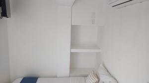 圣布拉斯BAOS的卧室拥有白色的墙壁,配有带枕头的床铺。