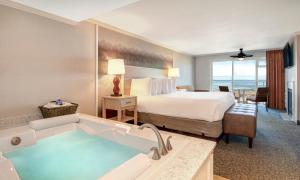 卡农海滩佳能海滩霍尔马克度假酒店的酒店客房配有一张床和浴缸。
