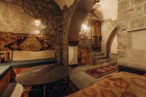 乌奇希萨尔Anatolia Raymonde Cave House的一间设有石墙的房间,里面设有桌子