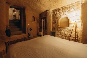 乌奇希萨尔Anatolia Raymonde Cave House的卧室配有一张石墙床