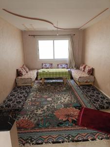 拜尔坎appartement berkane的客厅配有桌子和地毯。