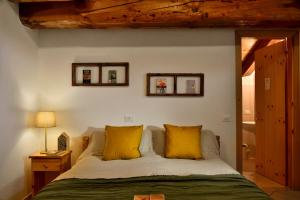 CanosioRifugio Lou Lindal的一间卧室配有一张带两个黄色枕头的床