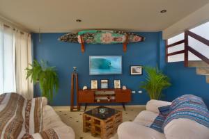 蓬塔赫尔莫萨Casa mar surfhouse的带沙发和蓝色墙壁的客厅