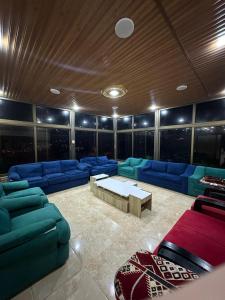 Sūfفيلا الجبل的大型客厅配有蓝色的沙发和桌子