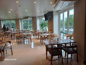 格拉玛多Laghetto Golden Resort的餐厅设有木桌、椅子和窗户。