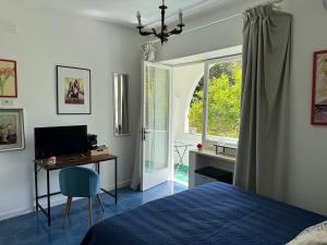 卡普里Villa Striano Capri的一间卧室配有一张床、一张书桌和一个窗户。