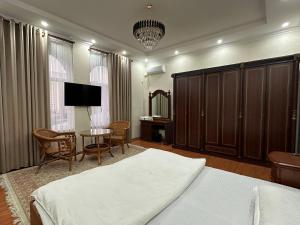 杜尚别Hello Dushanbe Hostel的一间卧室配有一张床、一张桌子和一台电视。