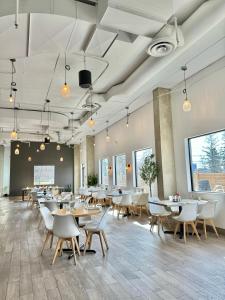 卡尔加里Divya Sutra Plaza and Conference Centre Calgary Airport的用餐室配有桌椅