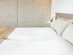 托尔斯港佛洛雅酒店的卧室配有白色的床和灯