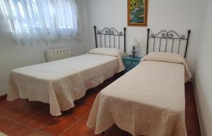 科尔多瓦Casa San Francisco de Asís的客房内的两张床和白色床单