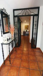 科尔多瓦Casa San Francisco de Asís的走廊设有瓷砖地板和开放式门