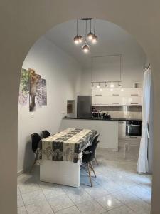 雅典Private Spacious Apartment的一间带桌椅的厨房和一间带白色橱柜的厨房