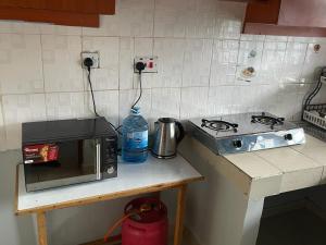 BometJojo's Homestay 2 - Bomet Town的厨房柜台配有微波炉和炉灶。