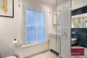 泰晤士河畔里士满1 Bedroom Apartment - Central Richmond-upon-Thames的带淋浴和卫生间的浴室以及窗户。