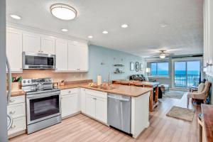 费南迪纳比奇306 Coral Sands的一间厨房,配有白色的橱柜,享有海景