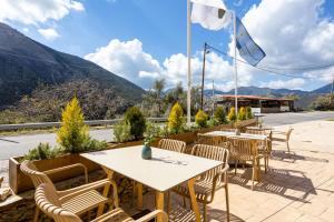 ArtemisíaDenthis Hotel - Taygetos Mountain Getaway的庭院配有桌椅,背景为山脉