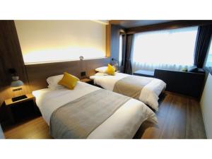 鸳泊Rishiri Fuji Kanko Hotel - Vacation STAY 63401v的酒店客房设有两张床和窗户。