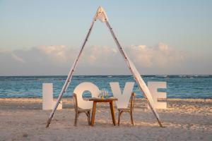蓬塔卡纳The Westin Puntacana Resort的海滩上的桌椅,上面有一句爱的话