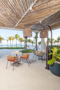 蓬塔卡纳The Westin Puntacana Resort的一个带桌椅的户外庭院和大海