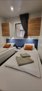 比奥格勒·纳·莫鲁Mobile home JOY的一间卧室设有两张床和窗户。