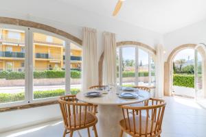 哈维亚Chalet independiente a 50 metros de Cala Blanca的一间带桌椅和窗户的用餐室