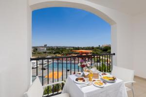 阿尔布费拉Regency Salgados Hotel & Spa的餐桌,享有泳池美景