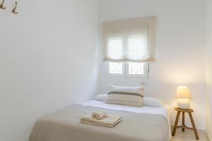 哈维亚Chalet independiente a 50 metros de Cala Blanca的白色卧室,配有带毛巾的床