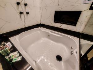 圣保罗Único Motel Faria Lima的浴室设有白色浴缸,拥有大理石墙壁。