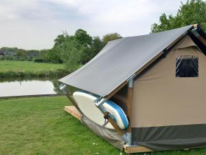 蒂尔Safari Lodge Aan de Linge的湖前带吊床的帐篷