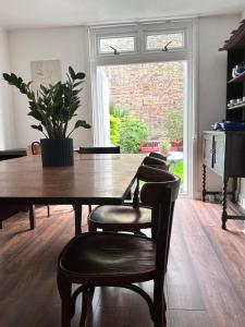 伦敦Charming, Renovated Residence in Willesden Green的餐桌、椅子和盆栽