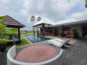 PenginyahanBelvilla 93799 Kasuari Villa Three Bedroom At Taro Village Ubud的一座带游泳池和房子的别墅