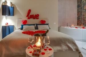 夏卡!!! IDROMASSAGGIO !!! - Love Suite的一间卧室配有一张带两杯眼镜和浴缸的床