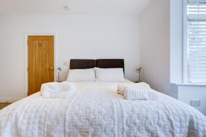 布伦特伍德Spacious Bedroom Ensuite in Brentwood Free Parking - Room 1的一张白色的床,上面有两个枕头