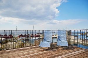 海斯勒Hotel Kysten的两把蓝色椅子坐在俯瞰着码头的阳台