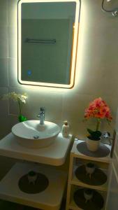 卡西奥皮Panayota Apartments的浴室设有水槽、镜子和鲜花