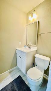 休斯顿Cozy location in Midtown!的一间带卫生间、水槽和镜子的浴室