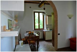 锡耶纳“Il Nespolino” Tuscan Country House的厨房以及带桌椅的用餐室。