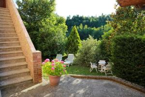 锡耶纳“Il Nespolino” Tuscan Country House的庭院配有椅子、桌子和鲜花