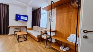 培拉特Hotel Republika Berat的一间配备有沙发及电视的酒店客房