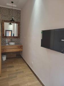 博博迪乌拉Villa Soudan的墙上设有1间带平面电视的浴室