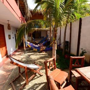 曼克拉Casa Máncora Guesthouse的一个带吊床和棕榈树的庭院