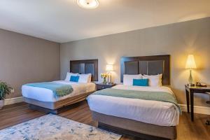 康科德森特尼尔酒店的酒店客房 - 带两张带蓝色枕头的床