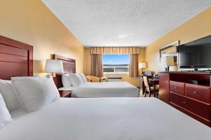 威廉斯莱克Coast Fraser Inn的酒店客房设有两张床和一台平面电视。